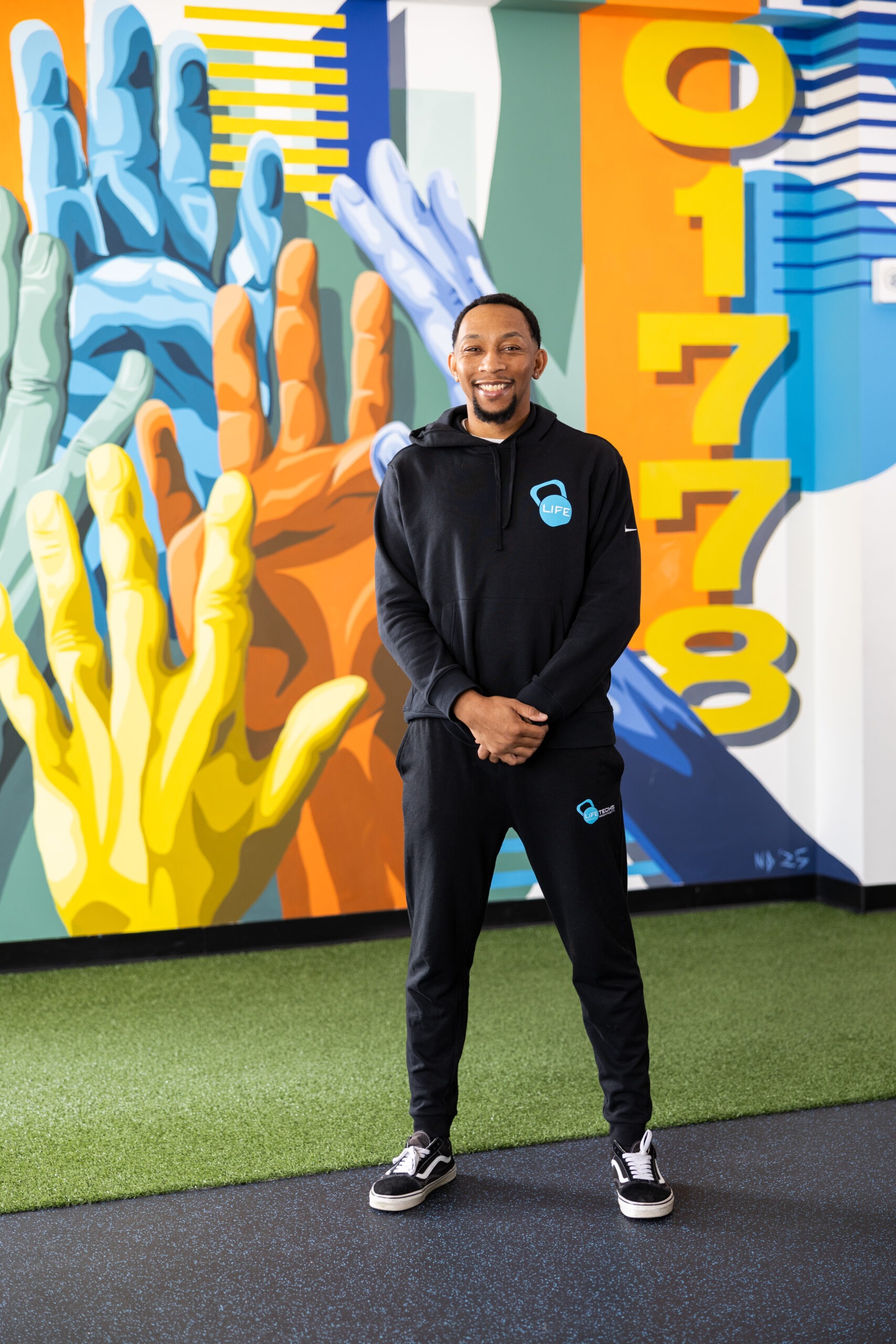 Curtis in front of the zip code mural